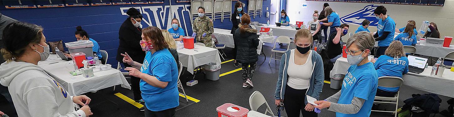 students and staff at a COVID vaccine clinic